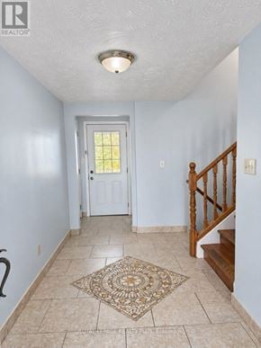 Hamilton (Binbrook) apartment for rent - A hallway with a rug on the floor and a staircase on the right.