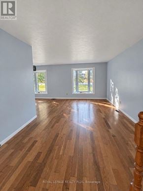 Hamilton (Binbrook) apartment for rent - A room with wooden flooring and two windows.