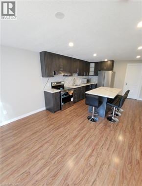 Breslau apartment for rent - A modern kitchen with dark wood cabinets and a white island.