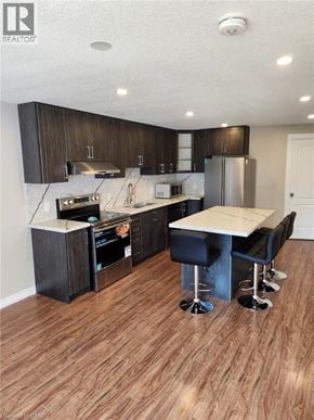 Breslau apartment for rent - A modern kitchen with dark wood cabinets and a white island.