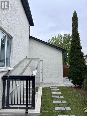 Vaughan (Maple) apartment for rent - A white house with a black gate and a stone pathway leading to the entrance.