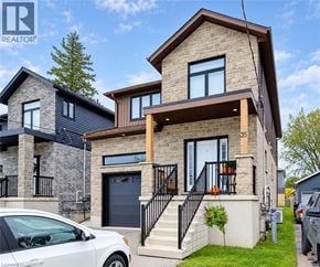Kitchener apartment for rent - A modern two-story house with a garage and a car parked in front.