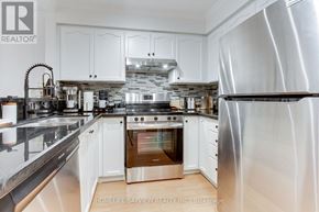 Vaughan (Islington Woods) condo for rent - A modern kitchen with white cabinets and stainless steel appliances.