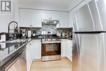 Vaughan (Islington Woods) condo for rent - A modern kitchen with white cabinets and stainless steel appliances.