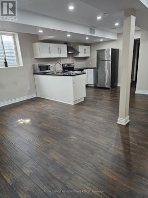 Milton (Sc Scott) apartment for rent - A kitchen with white cabinets and a black fridge.