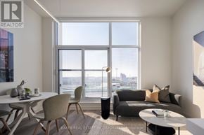 Toronto (Waterfront Communities) condo for rent - A living room with a couch, chairs, and a dining table with a view of the city.