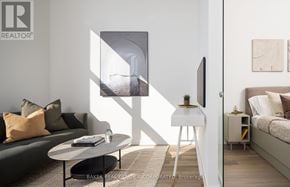 Toronto (Waterfront Communities) condo for rent - A living room with a couch, a table, and a painting on the wall.