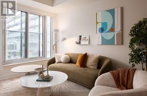 Toronto (Waterfront Communities) condo for rent - A living room with a couch, a table, and a painting on the wall.