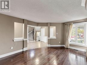 Mississauga (Central Erin Mills) apartment for rent - A spacious room with wooden floors and a staircase in the background.
