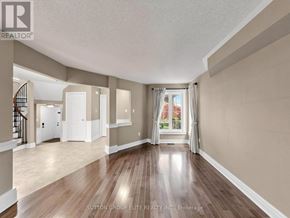 Mississauga (Central Erin Mills) apartment for rent - A spacious room with wooden floors and a staircase on the left side.