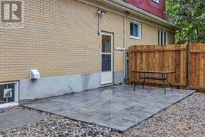 Ottawa apartment for rent - A patio with a table and chairs is surrounded by a wooden fence.