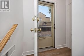 Ottawa apartment for rent - A white door with a gold handle is open to a hallway.