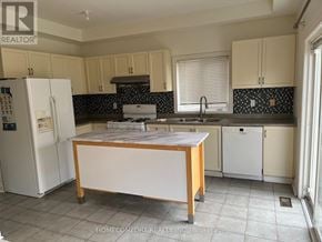 Vaughan (Vellore Village) apartment for rent - A kitchen with a white fridge, a wooden island, and a black and white backsplash.