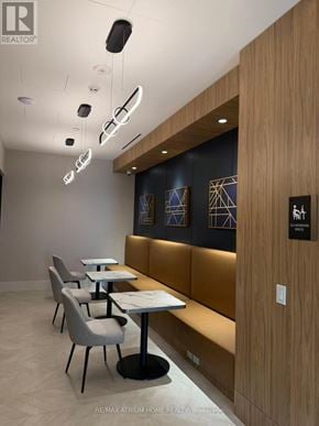 Vaughan (Vaughan Corporate Centre) condo for rent - A modern dining area with wooden booths and white tables.