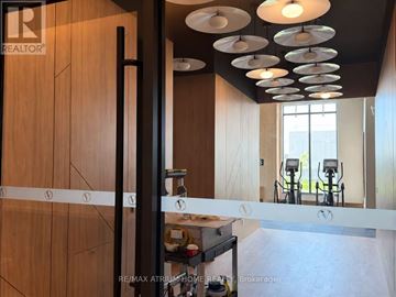 Vaughan (Vaughan Corporate Centre) condo for rent - A modern kitchen with wooden cabinets and a black pole.