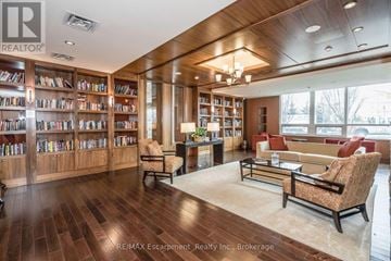 Mississauga (Clarkson) condo for rent - A living room with a wood floor and a bookshelf filled with books.