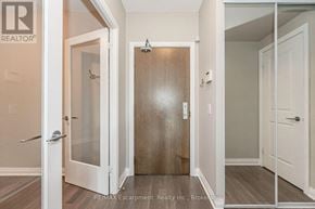 Mississauga (Clarkson) condo for rent - A white door with a glass window is in a hallway.