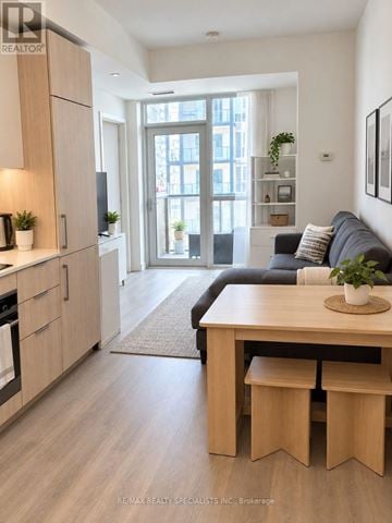 Toronto (Niagara) condo for rent - A modern kitchen with a dining table and a couch in the living room.