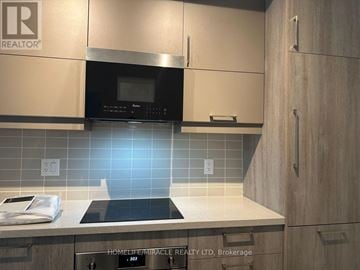 Markham (Unionville) condo for rent - A modern kitchen with a black microwave above the stove.
