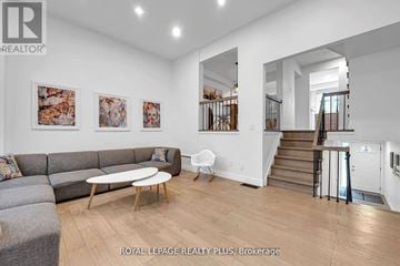 Mississauga (Rathwood) townhouse for rent - A living room with a grey couch and a wooden coffee table.