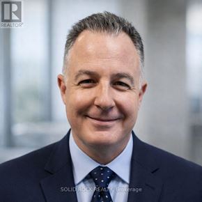 Ottawa condo for rent - A man in a suit with a dotted tie smiles at the camera.