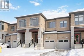 Whitby (Rolling Acres) townhouse for rent - A white car is parked in front of a building with a sign that says "REALTOR".