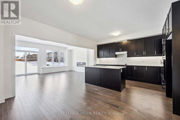 Whitby (Rolling Acres) townhouse for rent - A spacious kitchen with black cabinets and a wooden floor.