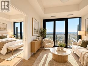 Kitchener condo for rent - A well-lit, spacious bedroom with a view of the cityscape outside the large windows.