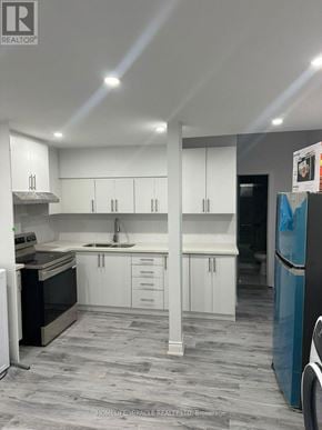 Brampton (Credit Valley) apartment for rent - A modern kitchen with white cabinets and a grey floor.