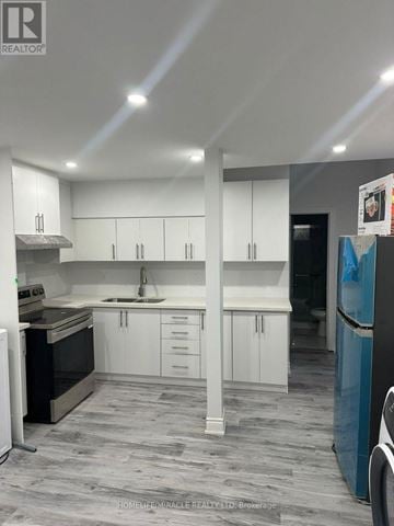 Brampton (Credit Valley) apartment for rent - A modern kitchen with white cabinets and a grey floor.