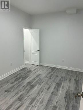 Brampton (Credit Valley) apartment for rent - A room with a white door and grey wood flooring.