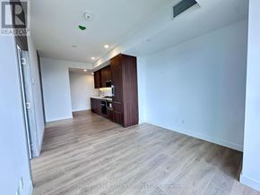 Toronto (Bayview Village) condo for rent - A spacious room with wooden flooring and a kitchenette in the corner.