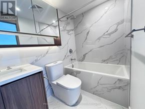 Toronto (Bayview Village) condo for rent - A white toilet in a marble bathroom.