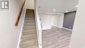 Ottawa townhouse for rent - A staircase with a carpeted runner and wooden handrail leads to a bedroom with a closed door.