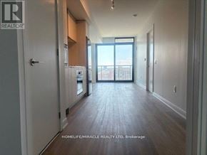 Mississauga (Cooksville) condo for rent - A long hallway with a door on the left and a balcony on the right.
