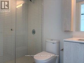 Mississauga (Cooksville) condo for rent - A white toilet in a bathroom with a glass shower door.