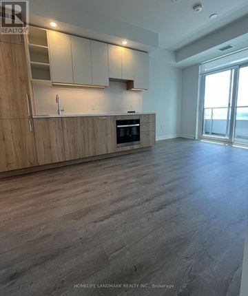 Vaughan (Concord) condo for rent - A spacious kitchen with wooden cabinets and a stainless steel oven.