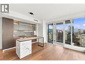 Vancouver apartment for rent - A modern kitchen with a marble island and a view of the city.