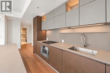 Vancouver apartment for rent - A modern kitchen with wooden cabinets and a stainless steel stove and sink.