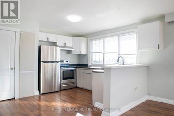 Bradford West Gwillimbury (Bradford) fourplex for rent - A kitchen with white cabinets and a stainless steel refrigerator.