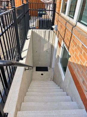 Hamilton (Stoney Creek Mountain) apartment for rent - A staircase with a black railing and a brick wall.