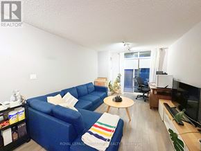 Toronto (Dovercourt-Wallace Emerson-Junction) condo for rent - A living room with a blue couch, a coffee table, and a television.