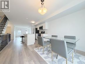 Oshawa (Windfields) townhouse for rent - A modern dining room with a glass table and grey chairs.