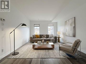 Oshawa (Windfields) townhouse for rent - A well-lit living room with a brown sofa, a coffee table, and a large painting on the wall.