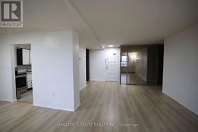 Waterloo condo for rent - A large empty room with a kitchen area in the background.