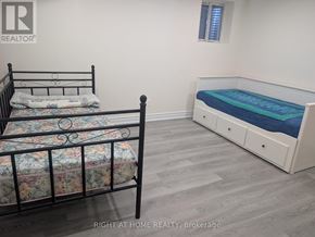 Ajax (Central West) apartment for rent - A bedroom with a black metal bed frame and a white bed with a blue mattress.