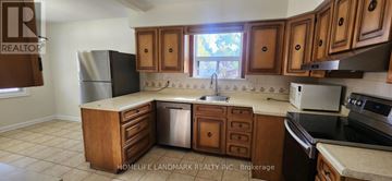 Toronto (Wexford-Maryvale) apartment for rent - A kitchen with wooden cabinets and a refrigerator.