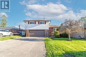 Oshawa (Donevan) apartment for rent - A house with a garage and a tree in front of it.