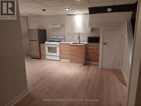Oshawa (Donevan) apartment for rent - A kitchen with wooden floors and white appliances.
