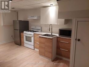Oshawa (Donevan) apartment for rent - A kitchen with wooden floors and white appliances.